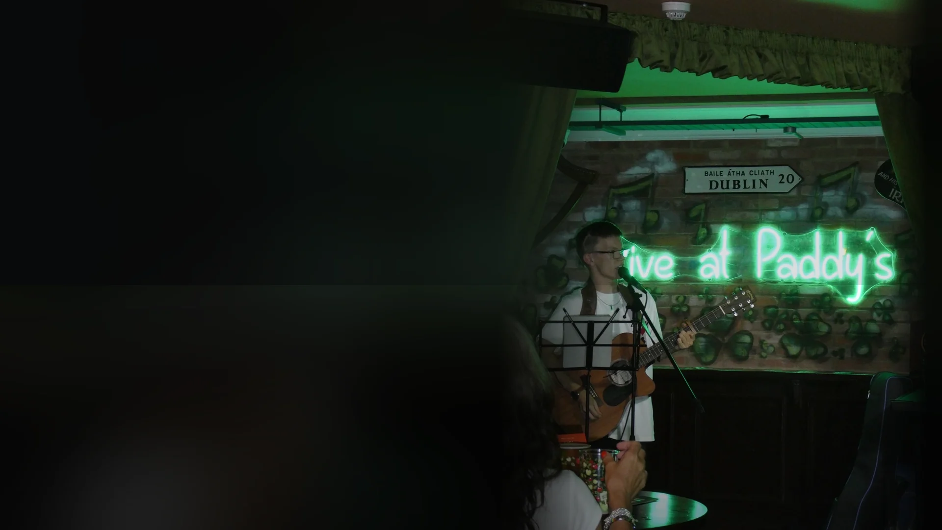 Harry Basnett singing and playing acoustic guitar at a live pub performance in Cumbria